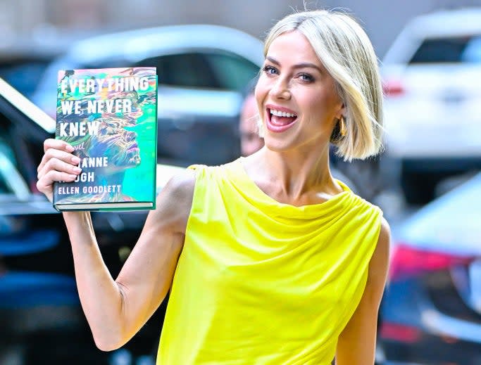 Julianne Hough, smiling, wearing a cute jumpsuit, holding a cup of "All We Didn't Know" by Jeanne Ryan and Joyellen Goodbott