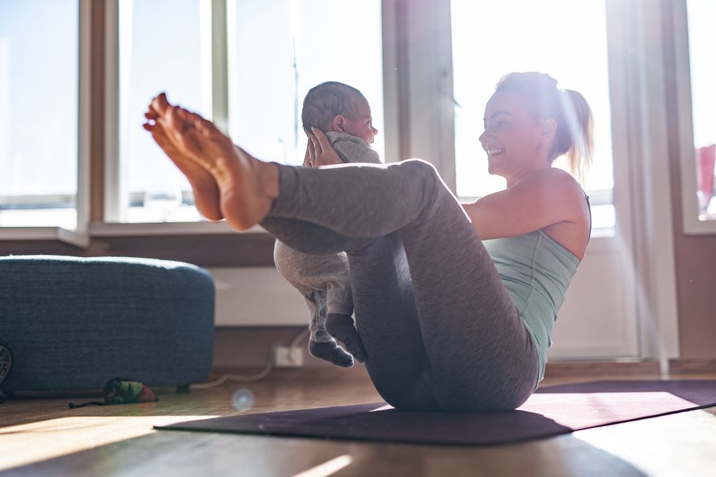 Mother and baby boy exercising at home.