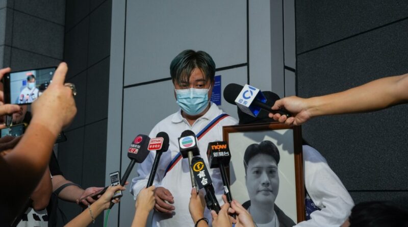 The brother of a man who died after being shot by the police holds a picture of his dead brother outside the police headquarters in Wan Chai, on September 22, 2024. Photo: Kyle Lam/HKFP.